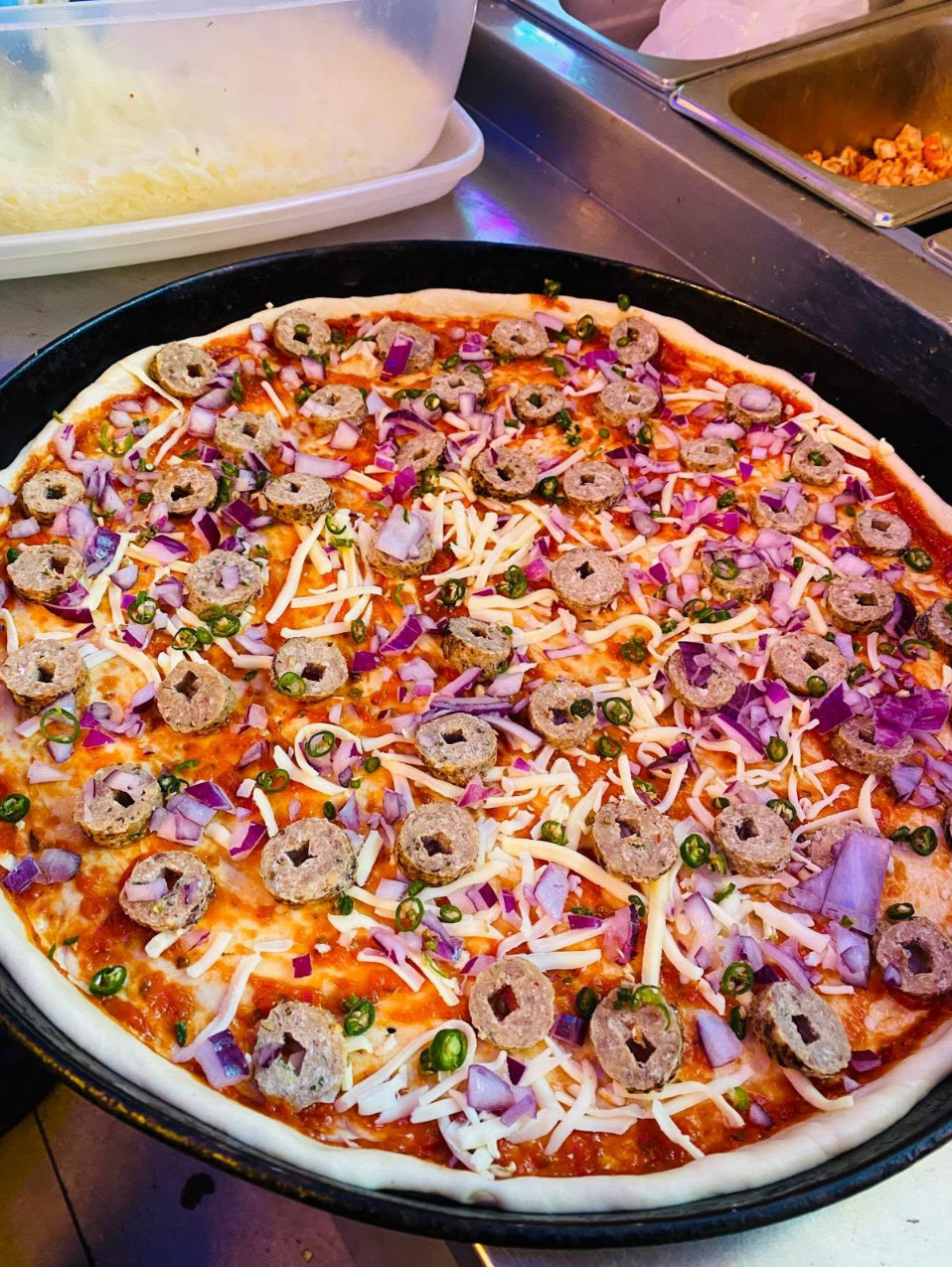 Keema special pizza being prepared with mince, onion and green chilli